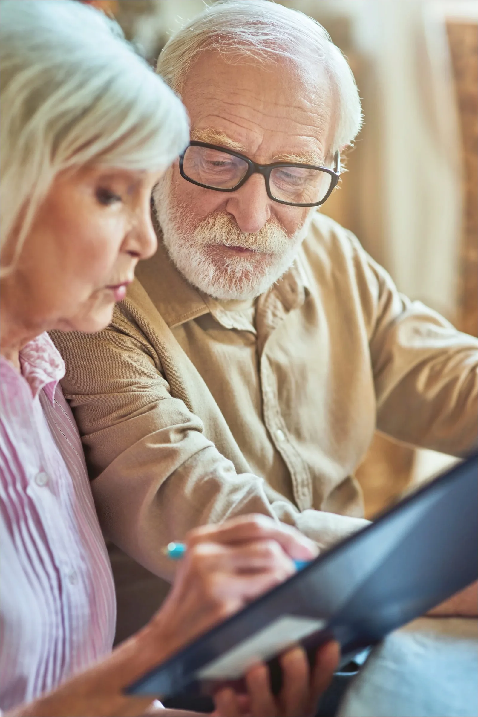 An older couple reviewing financial paperwork together at home
