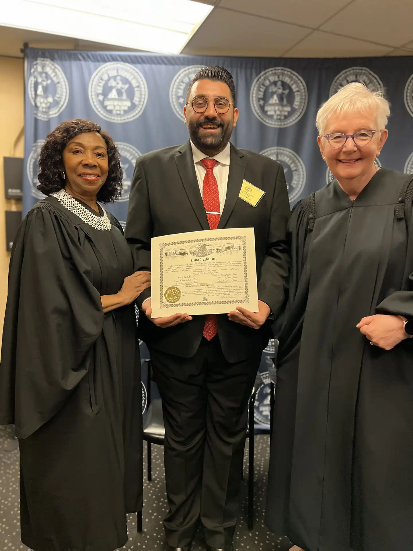 Emad Mahou receiving his license from Chief Justice Mary Theis of the Illinois Supreme Court